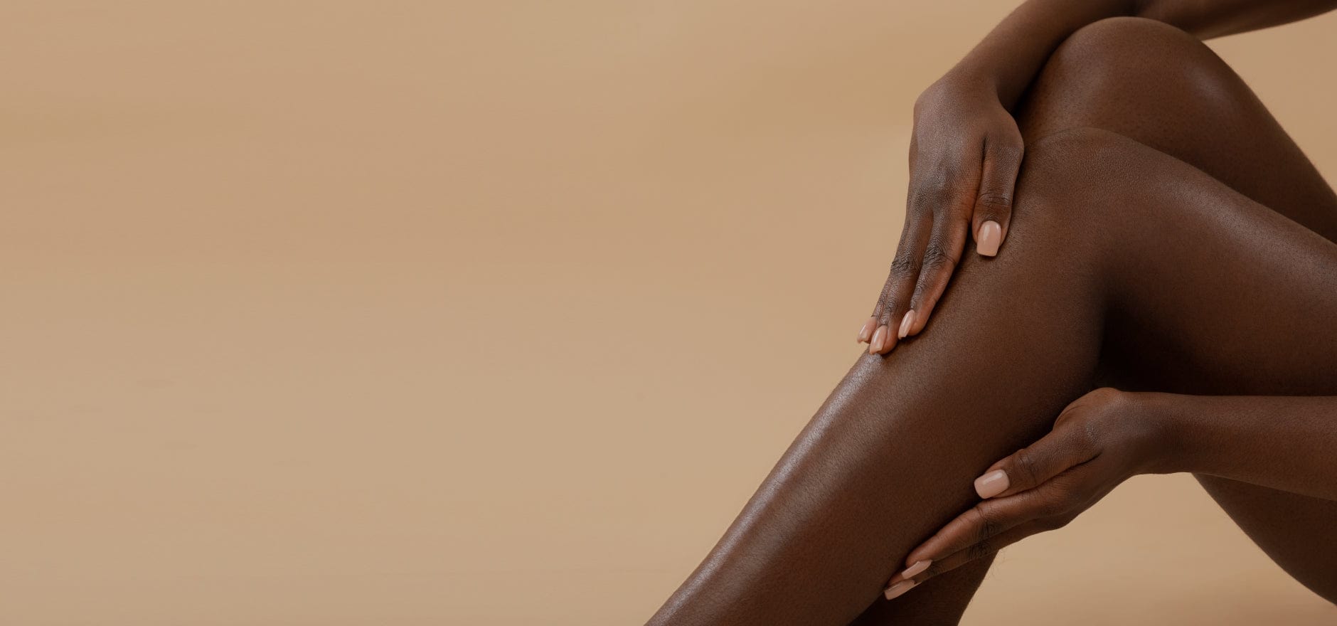 Woman with dark skin touching smooth legs after using Epilaser 980 hair removal